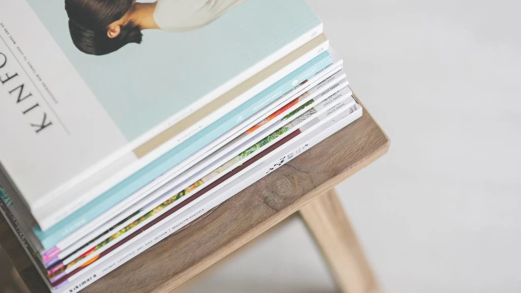 A printed flat-fee proposal sits beside a laptop displaying a launched website, on a warm cream desk.