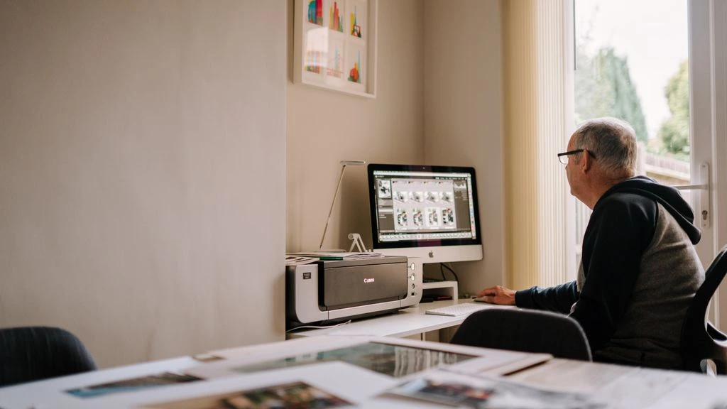 A senior designer's workstation showing a near-final shipped homepage composition on screen, the production evidence behind the 14-day guarantee.